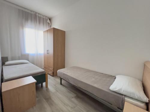 a small bedroom with a bed and a cabinet at Appartamenti Diplomatic-Residence Fronte mare-Piazza Torino-Lido di Jesolo in Lido di Jesolo