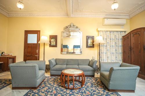 a living room with two blue couches and a table at Nilambag Palace Hotel in Bhavnagar