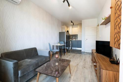 ein Wohnzimmer mit einem Sofa und einem Tisch in der Unterkunft Central Point Premium + in Ruse