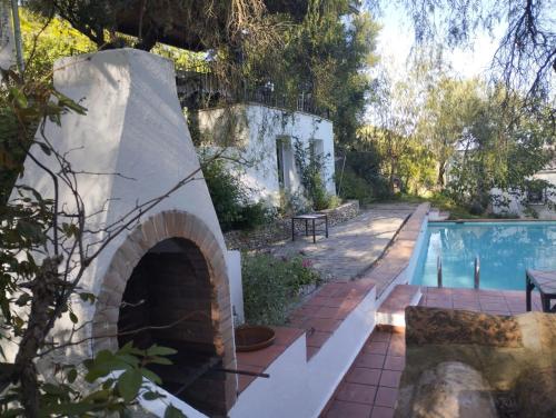 un patio trasero con piscina y una casa en Casa de campo Fuencaliente, entorno natural, chimenea, piscina en Cañete la Real