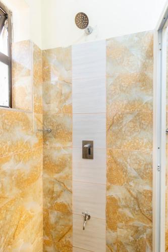 a bathroom with a shower with a stone wall at Mombasa Nyali Beachfront Apt in Mombasa