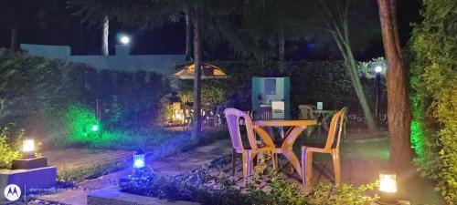 a table and chairs in a yard at night at KWERI GUEST HOUSE in Mbarara