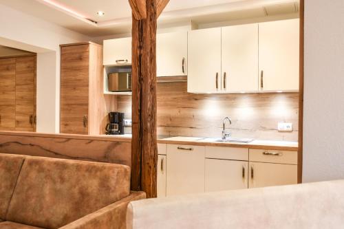 a kitchen with white cabinets and a sink at Hotel Lärchenhof in Lermoos