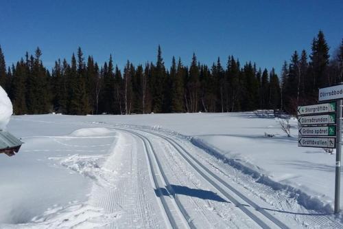 a road covered in snow with street signs and trees at Bydalsfjällen Östersund Åre Jämtland in Oviken
