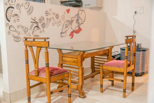 einen Glastisch und zwei Stühle in einem Zimmer in der Unterkunft bornil guest house in Guwahati