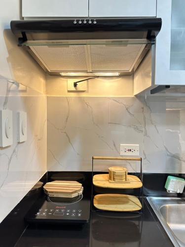 a kitchen with a stove top with wooden plates on it at Apartment Condotel at Hope Residences Trece Martires Cavite in Trece Martires