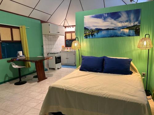 法赫的住宿－« Le Green House » by Meri lodge Huahine，一间卧室设有一张床和绿色的墙壁