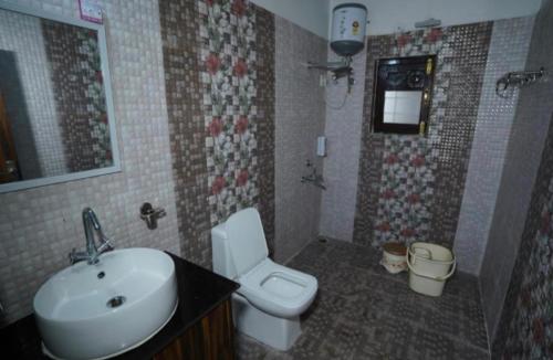 une salle de bain avec un lavabo et des toilettes dans l'établissement HIMALAYANBLUES COTTAGES&STAYS, à Mukteswar