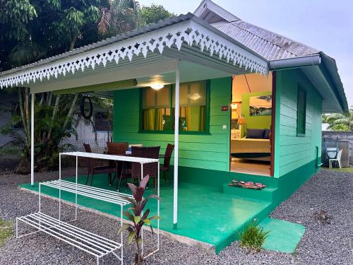a green house with a table in front of it at « Le Green House » by Meri lodge Huahine in Fare