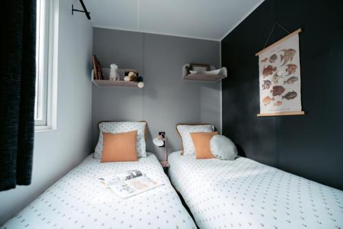 two twin beds in a bedroom with black walls at Camping de La Hallerais**** in Taden