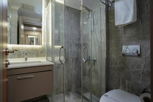 a bathroom with a shower and a toilet and a sink at Enerji Otel in Ankara