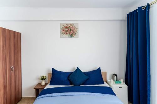 a bedroom with a blue bed with blue curtains at Casa Irina 2Mai in 2 Mai
