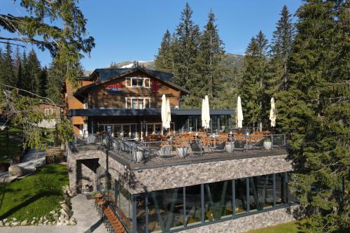 a large house with a patio in front of it at Hotel Björnson & Björnson TREE HOUSES Jasná in Demanovska Dolina