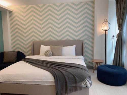 a bedroom with a bed with a chevron wall at Minilove Homestay in Tainan