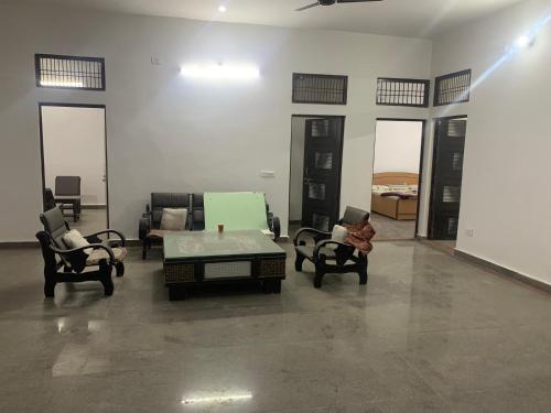 uma sala de estar com sofás, uma mesa e cadeiras em Shree Hari Kripa Dham em Jait