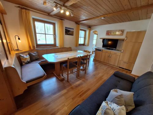 ein Wohnzimmer mit einem Sofa und einem Tisch in der Unterkunft BIO- Bauernhof Obermaurach in Walchsee