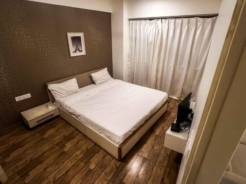 una piccola camera con letto e televisore di Ambition studio apartment at rajhans belliza a Bhatha