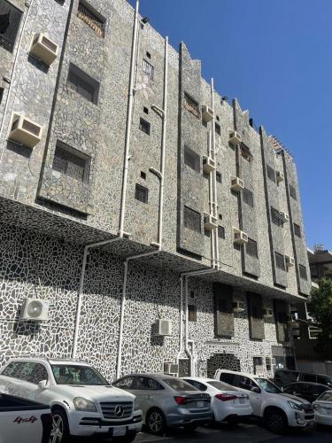 un edificio con coches estacionados frente a él en شقة كدي 1, en Al Masfalah