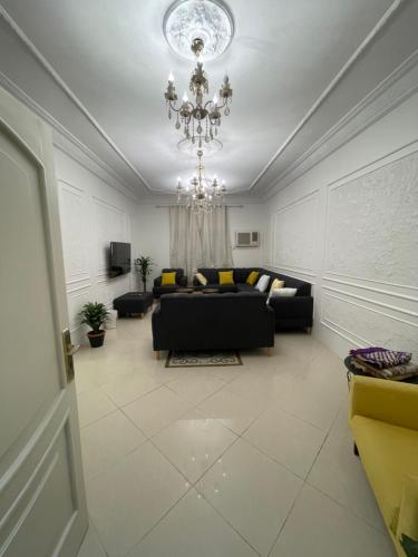 sala de estar con sofá y lámpara de araña en شقة كدي 1, en Al Masfalah