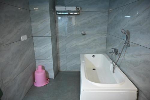 a bathroom with a shower and a tub and a sink at Hotel krishna in Nizāmābād