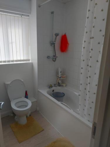 een badkamer met een toilet en een bad met een douche bij Private Room in Manchester