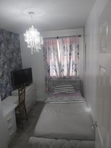 een slaapkamer met een bed, een bureau en een kroonluchter bij Private Room in Manchester