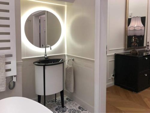 uma casa de banho com um lavatório e um espelho em Tom Sawyer’s 3 room Old Town Apartment em Breslávia