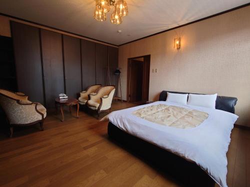 高山市にある高山ステイ 杜若 かきつばたのベッドと椅子のあるホテルの部屋