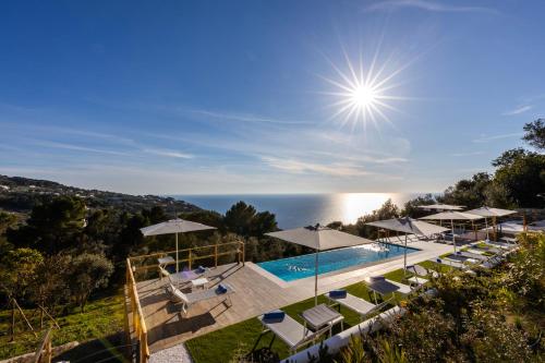 una imagen de una piscina con sombrillas y el océano en Dimora Maiuri L'Olivella, en Anacapri