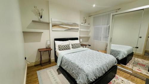 a small bedroom with two beds and a mirror at Sunny in London