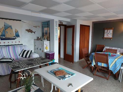ein Wohnzimmer mit einem Bett und einem Tisch in der Unterkunft Apartamento Coral con vistas al mar in Playa de Gandia