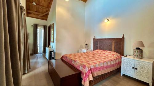 a bedroom with a bed and a dresser with a lamp at The Magnolia Lodge in Almora