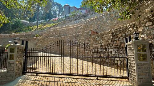 an iron gate in a brick wall with a stone wall at The Magnolia Lodge in Almora