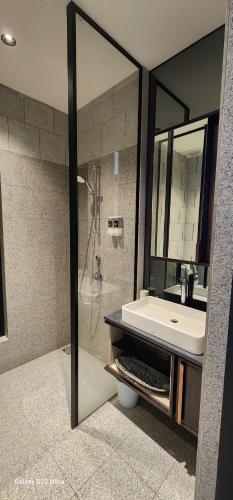 a bathroom with a sink and a shower with a mirror at The Scarletz By RSR in Kuala Lumpur