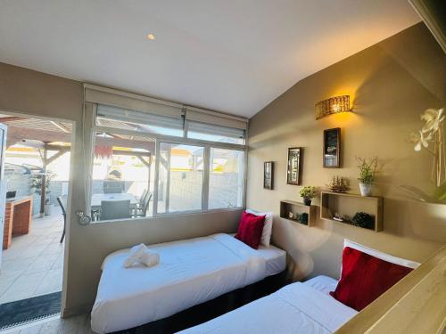 twee bedden in een kamer met een raam bij Casa Azul in Torreira