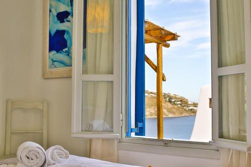 アギオス・イオアニス・ミコノスにあるVilla Athena by Elite Estatesのベッドルーム1室(海の景色を望む窓付)
