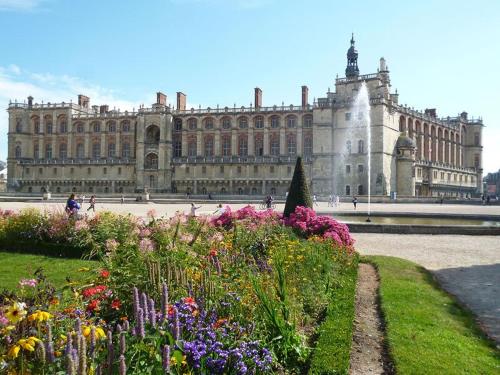 a large building with a bunch of flowers in front of it at bel appartement chic et cosy 78100 in Saint-Germain-en-Laye