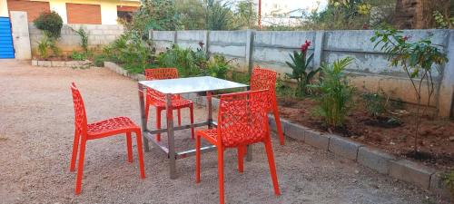a table and four chairs and a table and a table and chairs at Yogitha farmhouse and Home stay in Hyderabad