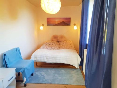 - une chambre avec un lit et une chaise bleue dans l'établissement Beach/Marina House, à Nørreby