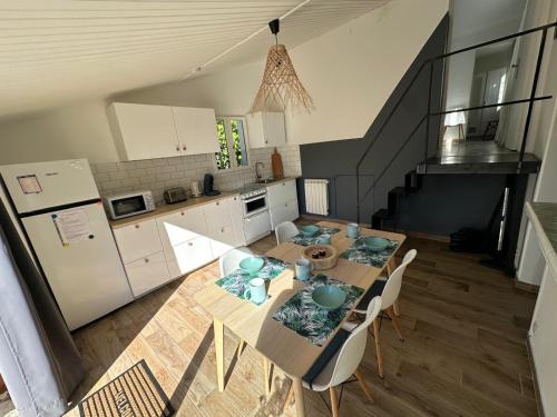 uma cozinha com uma mesa e cadeiras numa cozinha em Maisonnette à 200 m de la plage em La Seyne-sur-Mer