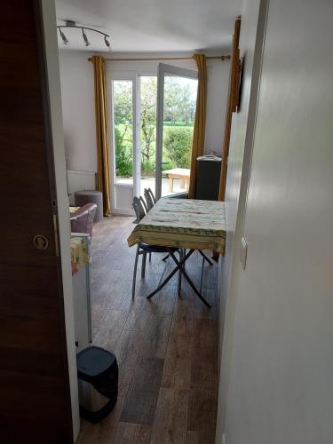 une salle à manger avec une table et une fenêtre dans l'établissement Gîte la Beautėe, à Hermanville-sur-Mer