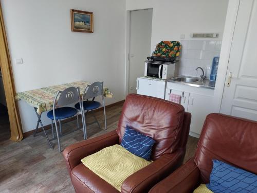 un salon avec un canapé et une table dans l'établissement Gîte la Beautėe, à Hermanville-sur-Mer