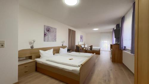 a bedroom with a large bed with white sheets at Hotel Engel in Kappel-Grafenhausen