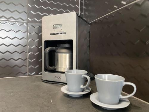 two coffee cups sitting on a counter next to a microwave at Plac Słowiański 10 - Silver in Świnoujście