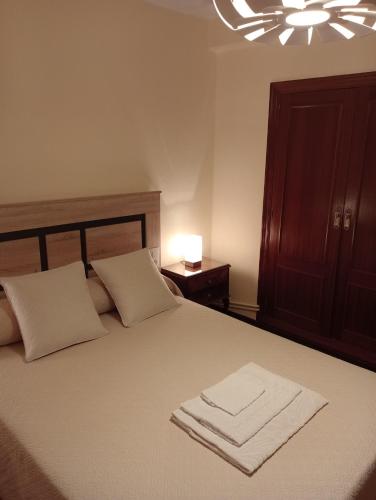 a bedroom with a bed with two towels on it at Habitacion matrimonial centro ciudad in Oviedo