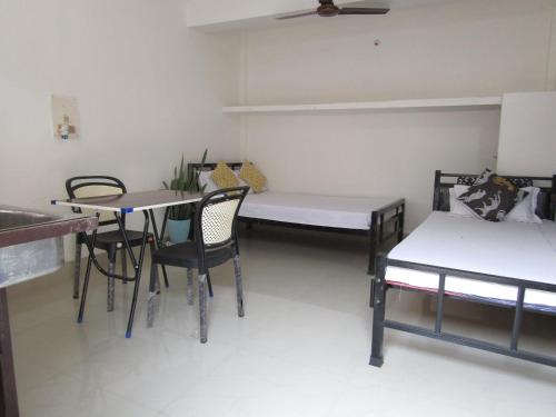 a room with a bed and a table and chairs at Cozy Home in Guwahati