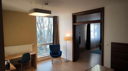 a room with a desk and chairs and a window at River View Apartments Hotel in Bratislava