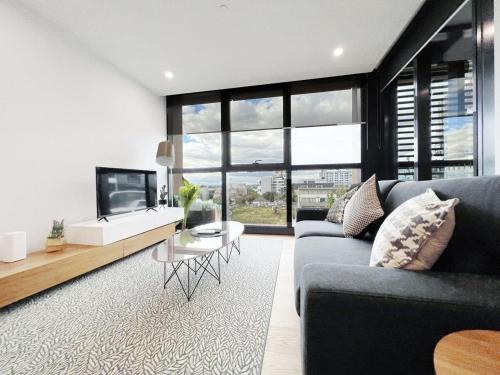 a living room with a couch and a tv at Myka Home New Apartment in Box Hill YS4A in Box Hill