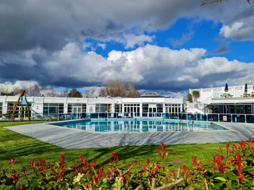 a large white building with a large swimming pool at Charming 3-Bed Holiday Home in Poole Rockley Park in Poole