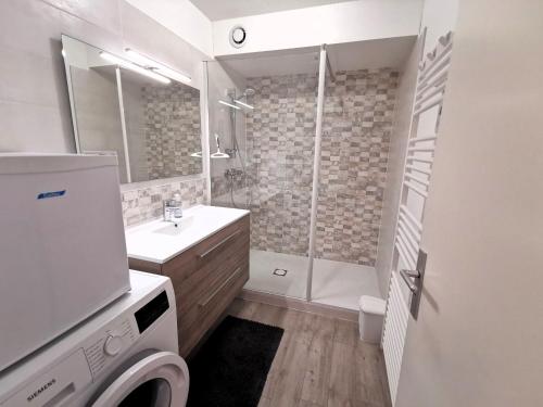 une salle de bain avec douche et lavabo et une machine à laver dans l'établissement Les Terrasses de l Atlantique, à Les Sables-dʼOlonne